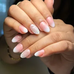 A still shot of the elegant ombre nails with a textured seashell accent. This is a perfect example of a sophisticated beach-themed design.
