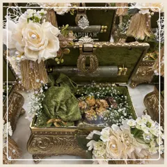 An olive green Rajwada chest filled with gourmet treats in a velvet potli and other treasures. I offer a wide range of products to curate the perfect gift for any occasion within this collection.