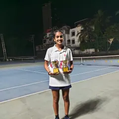 Tuhina Roy on court at night with her two trophies after finishing as Singles and Doubles Runner-up at the All India Championship Series U-14.