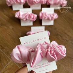 A small but sweet gesture for your bridesmaids. These pink satin scrunchies come with a personalized "Bridesmaid" card, making them a perfect addition to any proposal box or thank you gift.