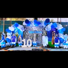 A perfect birthday party for a young cricket fan. This outdoor setup features a blue and white balloon arch, a sequin backdrop, and life-size cutouts of famous Indian cricketers.