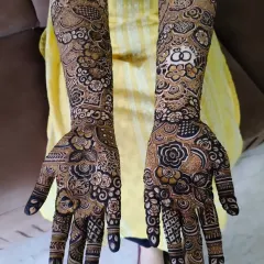 A full view of the engagement bride's mehndi, showing the ring design on one palm and other beautiful floral patterns.