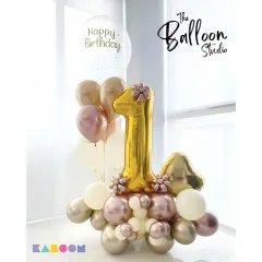 Celebrating a first birthday in style! This elegant gold and rose-gold balloon arrangement is a beautiful centerpiece for a milestone celebration.