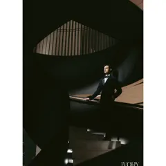 A portrait of the groom, exuding confidence and style. The play of light and shadow on the spiral staircase creates a moody, cinematic, and powerful image.