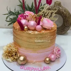 Our bestselling pink and golden design. This single-tier whipped cream cake is perfect for birthdays and anniversaries, featuring a beautiful ombre effect and decorated with fresh flowers, pink spheres, and dried grasses.