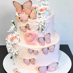 This delicate two-tiered cake is adorned with beautiful, lifelike butterflies, creating a whimsical and elegant look for a second birthday or any spring-themed celebration.