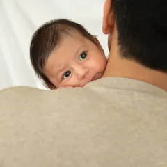 Safe in daddy's arms. This peek-a-boo moment over the shoulder is one of my favorite newborn poses, showing how tiny they are.