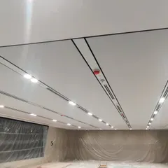 A view of a soundproof ceiling during installation. I use a fabric gripper system to create a smooth, monolithic surface that conceals acoustic insulation and integrates lighting fixtures.