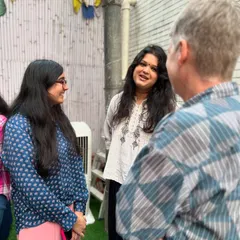 Participants from our 'Verse and Voice' workshop in conversation with a mentor in the outdoor area of our studio. These programs foster direct interaction and learning.