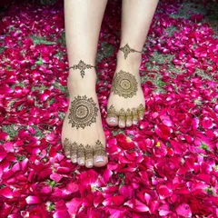 A simple and beautiful mandala design on the center of the feet, complemented by delicate patterns on the toes. This is perfect for a minimalist look, photographed on a bed of rose petals.