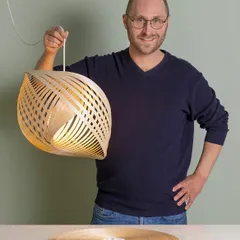 The Adilo lamp, a sustainable and timeless piece of Scandinavian wooden lighting. Designer Ilkka Kauppinen demonstrates how the flat-packed birch plywood unfurls into this beautiful, sculptural form.