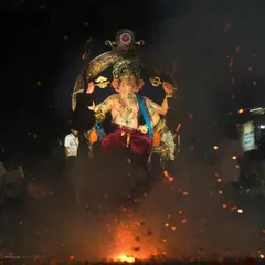 Capturing the raw energy of the Ganesh festival with sparks and smoke at the base of the Sanpada Cha Raja idol.