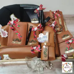 A large Christmas hamper centered around a 13-piece personalized leatherette set in tan and black, with each item customized for the recipient.