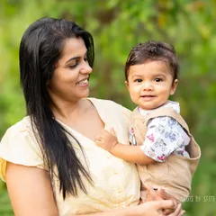 Outdoor sessions are filled with natural light and vibrant colors. This mother-son portrait in a lush garden setting is full of warmth and life.