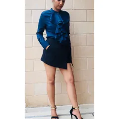 This look is all about creating a powerful, professional silhouette. The ruffled blouse adds a feminine touch while the asymmetrical skort and heels create a sharp, modern look perfect for the workplace. I guide clients on how to put together outfits that command attention.