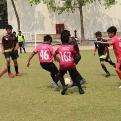 The intensity of a real match is where lessons are truly learned. Our players are locked in a battle for possession during a DFA League game, demonstrating the tactical awareness and competitive spirit we instill in every training session.