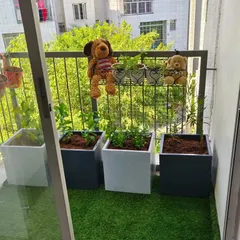 A clean and modern balcony garden we designed. This setup features stylish square planters on low-maintenance artificial grass, creating a simple yet elegant green space that is easy to care for.