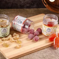 A delightful spread of our sweet and sour treats. This image showcases our healthy Amla Candy, flavorful Ram Ladoo Candy, and the ever-popular Orange Aam Papad.