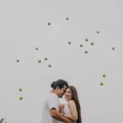 A creative shot with tennis balls seemingly frozen in the air around the couple. We love designing unique, dynamic portraits that are full of energy.