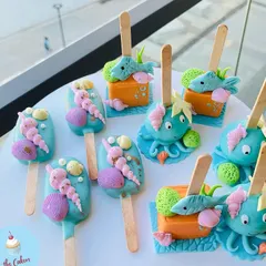 These under-the-sea themed cakesicles were designed as edible party favors. The set includes designs like seashells, octopuses, and fish, all handcrafted to match the mermaid party theme.