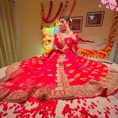 Another look at our stunning red bridal lehenga, perfect for an indoor pre-wedding or themed shoot. The intricate gold work looks beautiful on camera.