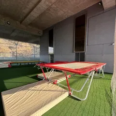 My gymnastics area basking in the golden hour light. The trampolines and safety mats are all set up, ready for athletes to come and practice their skills in a serene and inspiring setting.