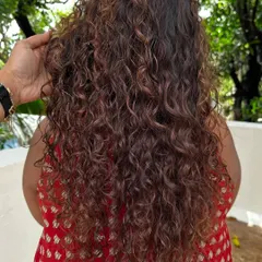 A closer look at the dimension we added with color. The highlights are painted on to follow the natural curl pattern, making them look sun-kissed.