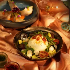 A plate that demands your full attention. Here, a creamy Burrata sits among fresh greens, ripe tomatoes, and avocado, ready to be dressed with infused oils. It’s a quiet performance of flavour and texture.