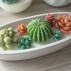 A custom-ordered cactus and succulent candle in a modern cement container. This piece contains 500 grams of scented soy wax.
