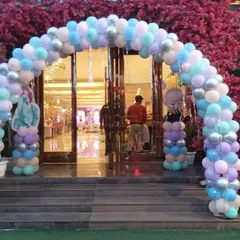 An entrance arch for a large party, decorated in pastel colors. This arch features balloons in light blue, purple, and silver, with cutouts of characters like Boss Baby and Elsa from Frozen.