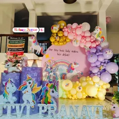 A wider view of the unicorn party, showing the full arrangement of props and the beautiful pastel and gold balloon arch.