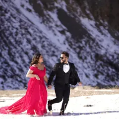 Another look from the snowy pre-wedding shoot, this hot pink infinity trail gown creates a stunning contrast. The matching tuxedo completes the perfectly coordinated couple's look.