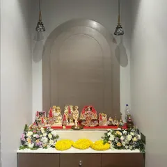 A clean and modern home mandir setup. We added two simple bouquets of fresh, colorful flowers and marigold garlands to beautify the space for a special prayer meeting.