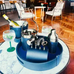 Our complete Bella Pelle Casa bar set in a sophisticated navy blue leather. This collection includes an ice bucket, shaker, bar tools, and a serving tray, making it the perfect gift for the modern host.