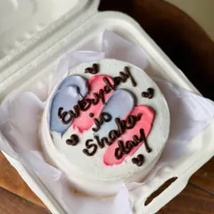 A motivational and fun bento cake with the message "Everyday is Shaka day." The colorful pink and purple brushstrokes add a splash of energy to the design.