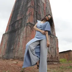 A designer shoot against a rustic, architectural backdrop. I styled this blue jumpsuit with a unique silhouette to create a strong contrast with the textured, earthy tones of the location.