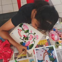 A student deeply engrossed in painting the lotus details on her Pichwai canvas. These workshops are a great way to connect with cultural traditions through creativity.