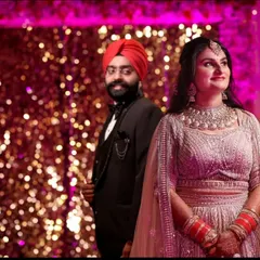 A Punjabi couple poses against a dazzling, sequined backdrop during their ring ceremony. This photo highlights the grand scale and festive decor of modern sangeet and reception events.