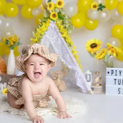 The pure joy of a six-month-old in our sunny sunflower setup. Her laughter is contagious!