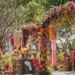 The entrance vignette, featuring a cabinet filled with colorful fabrics and floral arrangements, giving guests a taste of the detailed and lively decor inside.