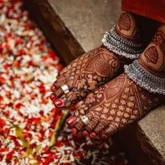 This professionally shot photo shows how beautiful the dark henna stain looks on the feet. The design features peacock motifs and is perfectly accessorized with silver anklets and toe rings.