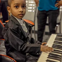 This young student, dressed up and ready to perform, perfectly captures the spirit of our academy. We build confidence and a love for music from the very first lesson.