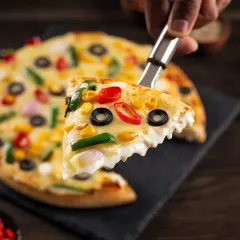 The perfect cheese pull from a slice of vegetarian pizza, a classic shot that emphasizes the gooey, melted mozzarella.