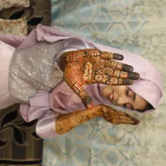 Another shot of my bride Taskeen, giving a closer look at the detailed henna on her palm, which includes personalized elements.