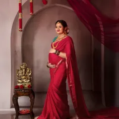 A portrait of pure elegance. Draped in a stunning red saree, this mama-to-be stands gracefully in our vintage arch setup, complete with a Ganesha idol for blessings.
