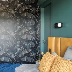 The master bedroom in Project 704 features a dramatic, custom-printed wardrobe with a tropical leaf pattern. The deep green walls and mustard yellow leather headboard create a rich, moody, and luxurious feel.