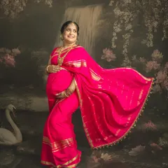 The joy of a mother-to-be in a vibrant pink saree. The flowing fabric and the artistic backdrop with a waterfall and swan come together to create a truly magical, painting-like effect.