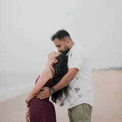 An intimate and romantic pose on the beach, with him kissing her forehead as the waves roll in. A timeless and emotional pre-wedding portrait.