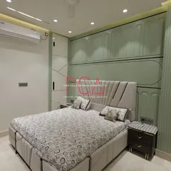 A view of the master bedroom in The Cursive Abode project, showcasing a bespoke design with intricate wall paneling and integrated lighting. The pastel green tones and fluted details create a serene yet sophisticated atmosphere, reflecting my ability to craft personalized and opulent living spaces.
