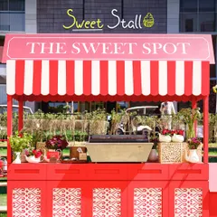 A charming "Sweet Spot" stall, designed like a vintage cart, offering delicious treats to guests. It's a delightful detail that adds to the festive atmosphere.